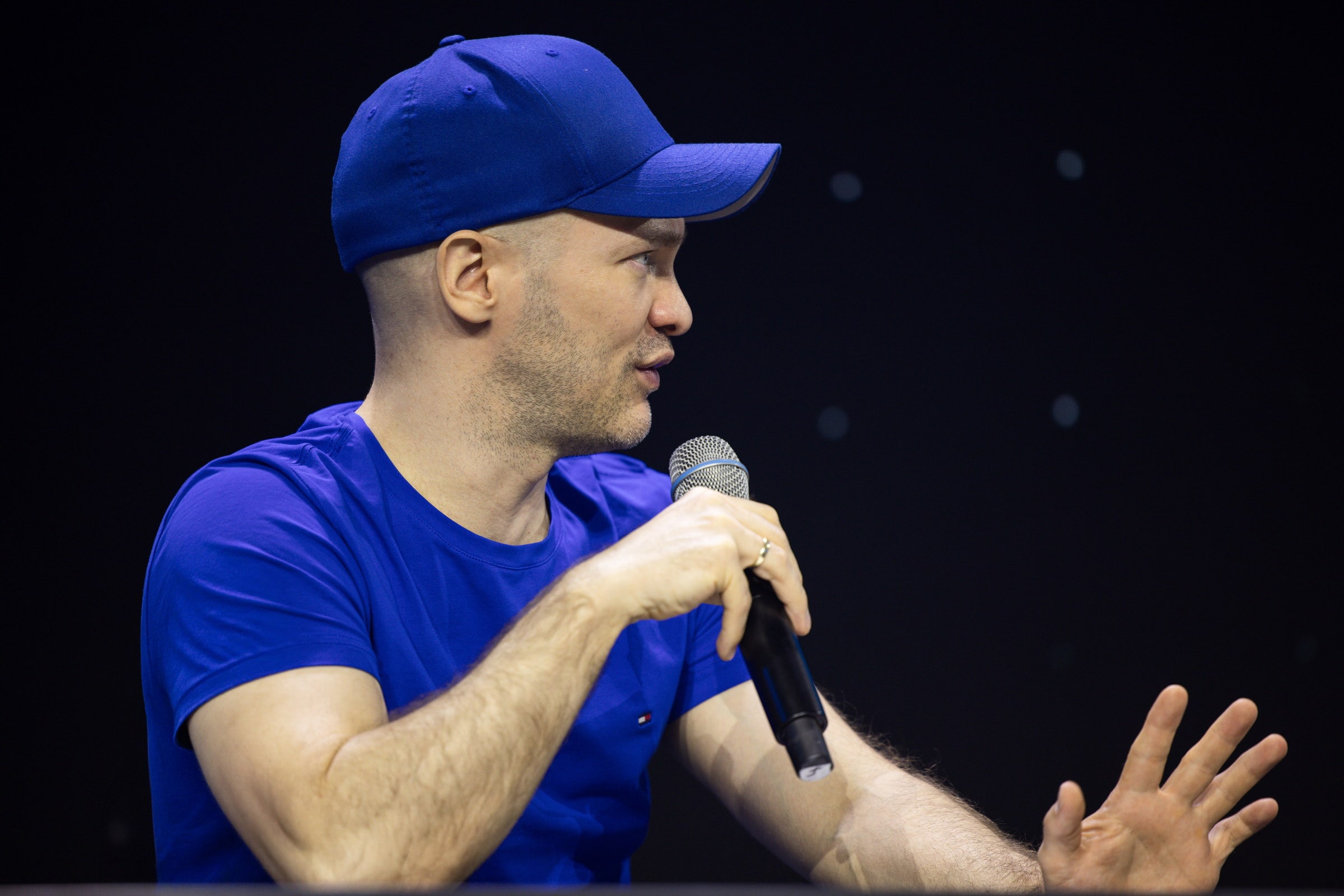 Joël Kaczmarek mit Handmikrofon auf der Bühne